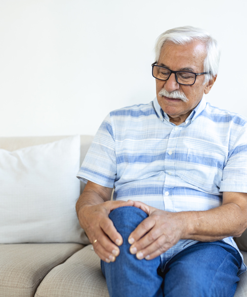 Elderly Man Sitting Sofa Home Touching His Painful Knee People Health Care Problem Concept Unhappy Senior Man Suffering From Knee Ache Home